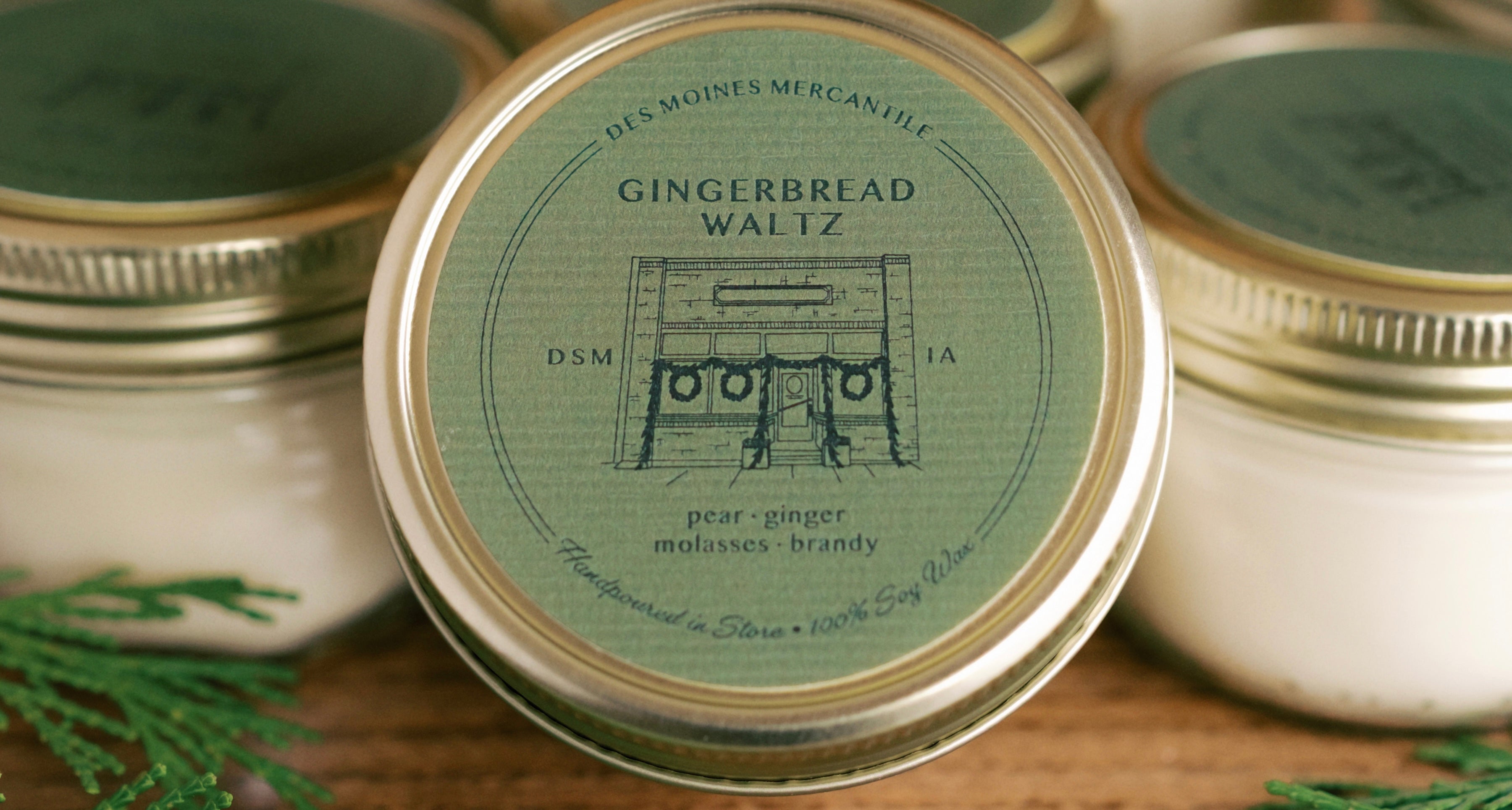 Candle in jar showing a green label that says "Gingerbread Waltz"